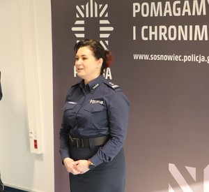 Zdjęcie przedstawia Zastępcę Komendanta Miejskiego Policji w Sosnowcu przemawiającą do zgromadzonych na sali osób.