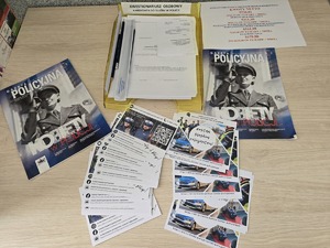 Zdjęcie przedstawia dokumenty - w tym kwestionariusz osobowy oraz ulotki &quot;Zostań Policjantem&quot; leżące na stole.