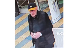 Zdjęcie przedstawia mężczyznę w pomarańczowo-czarnej czapce, czarnej kamizelce i bluzie.