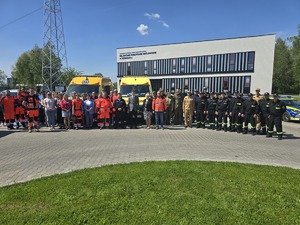 Zdjęcie przedstawia osoby oddające hołd przed budynkiem pogotowia pozujących do zdjęcia.