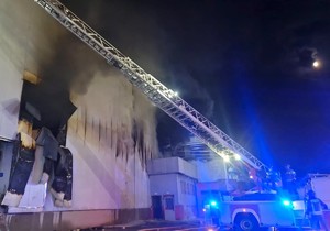 Zdjęcie przedstawia działania straży pożarnej podczas pożaru budynku.