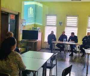 Zdjęcie przedstawia umundurowanych policjantów podczas debaty w sali.