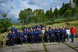 Zdjęcie przedstawia grupę umundurowanych policjantów pozujących do zdjęcia.