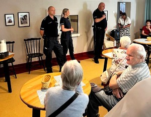 Zdjęcie przedstawia umundurowanych policjantów podczas debaty w sali.