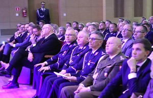 Zdjęcie przedstawia uczestników uroczystości w sali.
