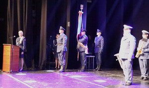 Zdjęcie przedstawia poczet sztandarowy oraz umundurowanych policjantów podczas uroczystości w sali.