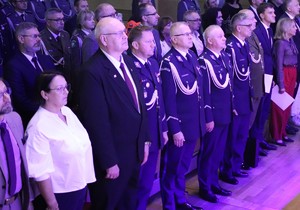Zdjęcie przedstawia uczestników uroczystości w sali.