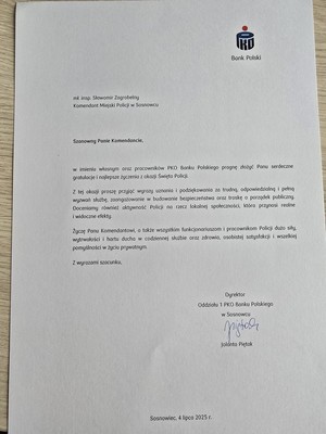 Zdjęcie przedstawia list o treści: &quot;PKO Bank Polski
mł.insp. Sławomir Zagrobelny Komendant Miejski Policji w Sosnowcu
Szanowny Panie Komendancie,
w imieniu własnym oraz pracowników PKO Banku Polskiego pragnę złożyć Panu serdeczne gratulacje i najlepsze życzenia z okazji Święta Policji.
Z tej okazji proszę przyjąć wyrazy uznania i podziękowania za trudną, odpowiedzialną i pełną wyzwań służbę, zaangażowanie w budowanie bezpieczeństwa oraz troskę o porządek publiczny. Doceniamy również aktywność Policji a rzecz lokalnej społeczności, która przynosi realne widoczne efekty.
Życzę Panu Komendantowi, a takie wszystkim funkcjonariuszom i pracownikom Policji dużo siły. wytrwałości i hartu ducha w codziennej służbie oraz zdrowia., osobistej satysfakcji i wszelkiej pomyślności w życiu prywatnym.
Z wyrazami szacunku,
Dyrektor Oddziału 1 PKO Banku Polskiego w Sosnowcu
Jolanta Piętak
Sosnowiec, 4 lipca 2025 r.&quot;