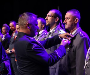 Zdjęcie przedstawia Przewodniczącego NSZZ Policjantów wręczającego medale.