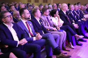 Zdjęcie przedstawia uczestników uroczystości w sali.
