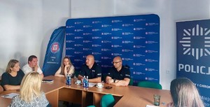 Zdjęcie przedstawia umundurowanych policjantów z uczestnikami szkolenia w sali.