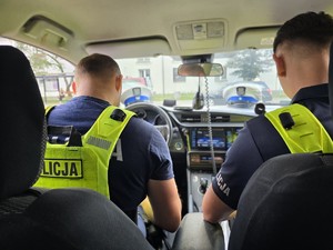 Zdjęcie przedstawia dwóch umundurowanych policjantów podczas czynności.