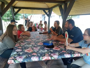 Zdjęcie przedstawia umundurowanego dzielnicowego wraz z grupą dzieci.