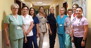 Zdjęcie przedstawia umundurowaną policjantkę oraz pracowników medycznych.