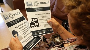 Zdjęcie przedstawia kobietę trzymającą w rękach ulotkę.