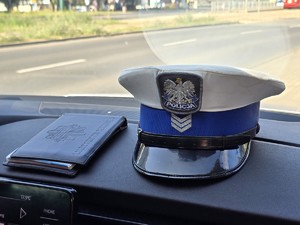 Zdjęcie przedstawia czapkę służbową oraz bloczek mandatowy.