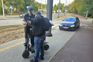Zdjęcie przedstawia umundurowanych policjantów oraz mężczyznę z hulajnogą.