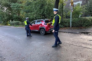 Zdjęcie przedstawia umundurowanych policjantów podczas czynności służbowych.