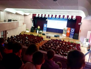 Zdjęcie przedstawia uczestników konferencji na scenie.