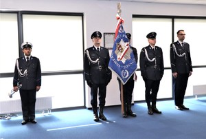 Zdjęcie przedstawia umundurowanych policjantów ze sztandarem Komendy Miejskiej Policji w Sosnowcu.
