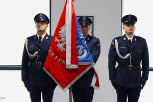 Zdjęcie przedstawia umundurowanych policjantów ze sztandarem Komendy Miejskiej Policji w Sosnowcu.