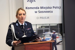 Zdjęcie przedstawia umundurowaną policjantkę przemawiającą podczas uroczystości.