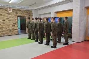 Zdjęcie przedstawia uczniów klas mundurowych podczas zajęć z instruktorem.