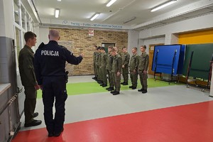 Zdjęcie przedstawia uczniów klas mundurowych podczas zajęć z instruktorem.