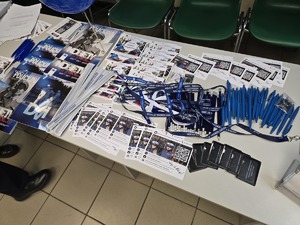 Zdjęcie przedstawia ulotki zachęcające do służby w Policji leżące na stole.