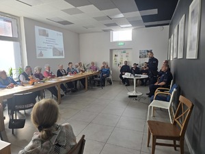 Zdjęcie przedstawia umundurowanych policjantów oraz uczestników debaty.