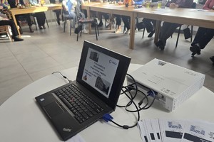 Zdjęcie przedstawia laptopa z wyświetloną prezentacją multimedialną z napisem "Porozmawiajmy o bezpieczeństwie. Bezpieczeństwo w miejscu zamieszkania."