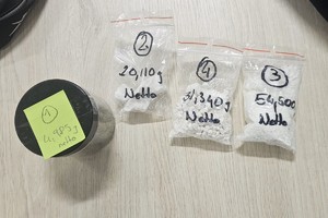 Zdjęcie przedstawia woreczki strunowe z zawartością białej substancji oraz słoik.