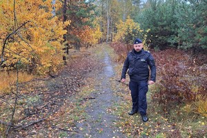 Zdjęcie przedstawia umundurowanego policjanta w lesie.