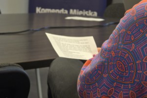 Zdjęcie przedstawia kobietę trzymającą w ręku kartkę.