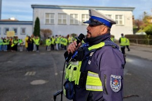 Zdjęcie przedstawia dzieci ubrane w kamizelki odblaskowe podczas wydarzenia.