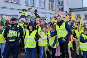 Zdjęcie przedstawia dzieci ubrane w kamizelki odblaskowe podczas wydarzenia.