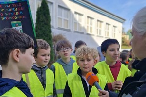 Zdjęcie przedstawia dzieci ubrane w kamizelki odblaskowe podczas wydarzenia.