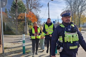 Zdjęcie przedstawia dzieci ubrane w kamizelki odblaskowe podczas wydarzenia.