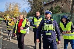 Zdjęcie przedstawia dzieci ubrane w kamizelki odblaskowe podczas wydarzenia.