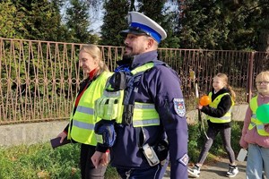 Zdjęcie przedstawia dzieci ubrane w kamizelki odblaskowe podczas wydarzenia.