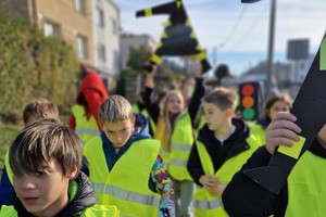 Zdjęcie przedstawia dzieci ubrane w kamizelki odblaskowe podczas wydarzenia.