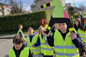 Zdjęcie przedstawia dzieci ubrane w kamizelki odblaskowe podczas wydarzenia.