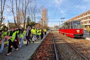 Zdjęcie przedstawia dzieci ubrane w kamizelki odblaskowe podczas wydarzenia.