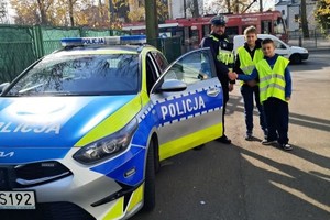 Zdjęcie przedstawia dzieci ubrane w kamizelki odblaskowe podczas wydarzenia.