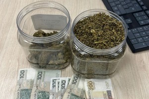 Zdjęcie przedstawia dwa słoiki z suszem roślinnym oraz pieniądze.