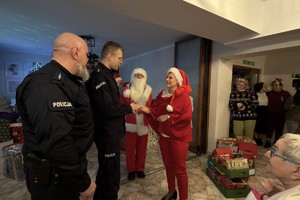 Zdjęcie przedstawia umundurowanych policjantów oraz kobietę podczas wydarzenia w Domu Pomocy Społecznej.