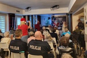 Zdjęcie przedstawia uczestników siedzących w sali podczas wydarzenia w Domu Pomocy Społecznej.