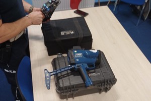 Zdjęcie przedstawia policjanta z wydziału ruchu drogowego prezentującego sprzęt służbowy.