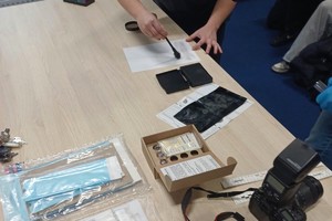 Zdjęcie przedstawia technika kryminalistyki podczas czynności.