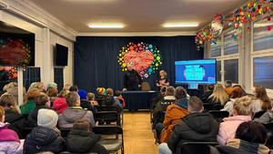 Zdjęcie przedstawia umundurowanego policjanta podczas spotkania z wolontariuszami.